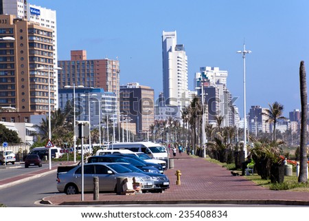 DURBAN; SOUTH AFRICA - DECEMBER 4; 2014 : Many unknown people on promenade amongst commercial and residential buildings along the 