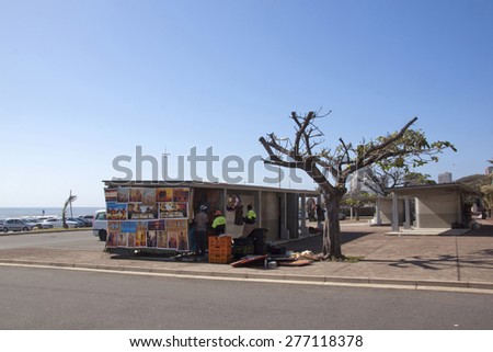 DURBAN, SOUTH AFRICA - DECEMBER 4, 2014: Three unknown people at vendor stall on beachfront in Durban, South Africa