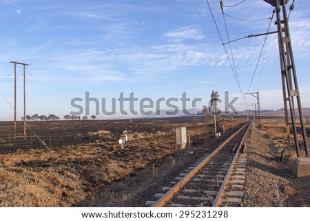 Early morning landscape of railway tracks running through dry wintry countryside in South Africa