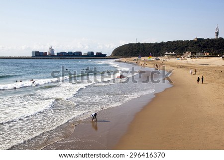 DURBAN, SOUTH AFRICA - JUNE 7, 2015: Many unknown people on Vetch\'s beach as container ship enters harbor in Durban, South Africa
