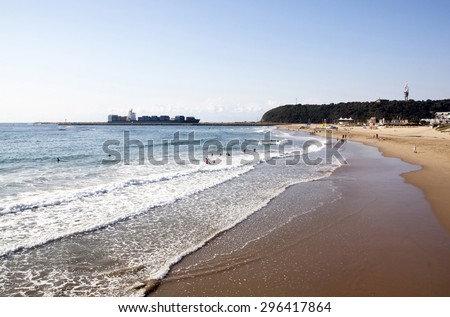 DURBAN, SOUTH AFRICA - JUNE 7, 2015: Many unknown people on Vetch\'s beach as ship enters harbor in Durban, South AFrica
