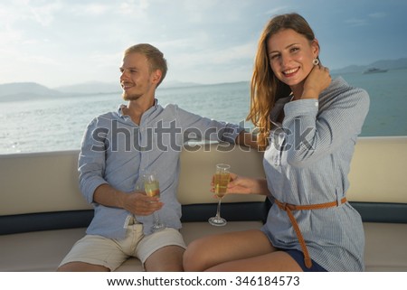 Romantic vacation . Beautiful couple drinking sparkling wine on the board of yacht