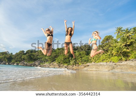 Summer holidays and vacation - girls jumping on the beach.Tropical vacation .Thailand . Phuket . Freedom beach.