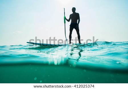 Stand up paddle board man paddleboarding . Young caucasian male model on Thailand beach on summer holidays vacation travel.