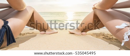 Tropical vacation. Two young women sitting on the beach and looking at sunset. Banner.