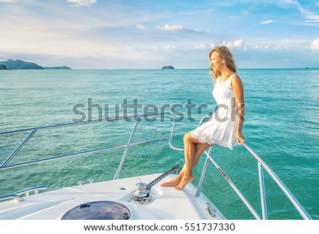 Young beautiful woman sitting on the yacht . Luxury travel on the yacht. Cruise vacation.