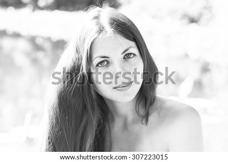 Young beautiful smiling girl with long hear on summer background