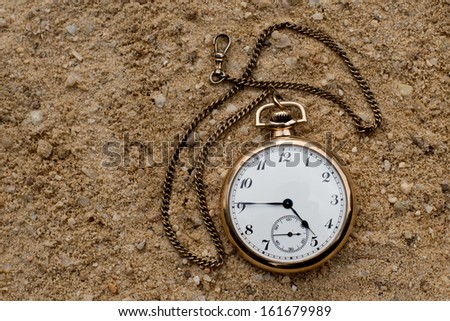 Antique pocket watch in the sand