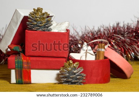 Opened red, pink and white paper Christmas present boxes, they contain Christmas tree decorations