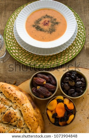 Iftar meal (time to break the fast) with sweet dry dates,apricot,black olives,soup,water and Ramadan bread.Beginning meal before main menu.Close up taken,isolated.