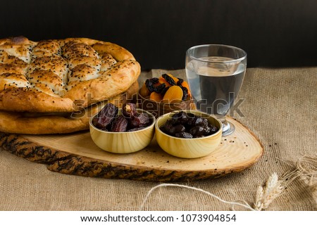 Iftar meal (time to break the fast) with sweet dry dates,apricot,black olives,soup,water and Ramadan bread.Beginning meal before main menu.Close up taken,isolated.