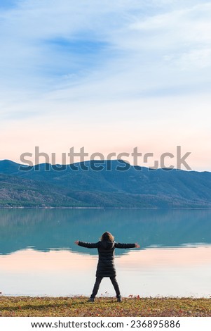 Young woman looking at a lakeside winter landscape