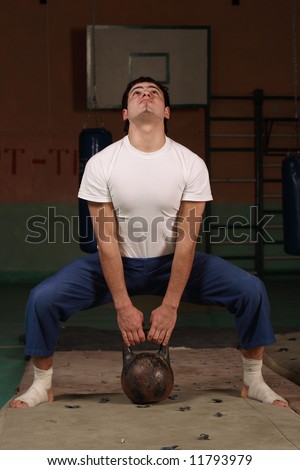 Young man works out with heavy weights