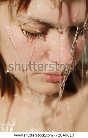 Close-up of beautiful wet woman face with water drop.