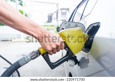 Pumping gas at gas pump. Closeup of man pumping gasoline fuel in car at gas station