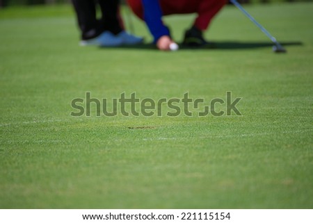Golf player finding the best putting line.