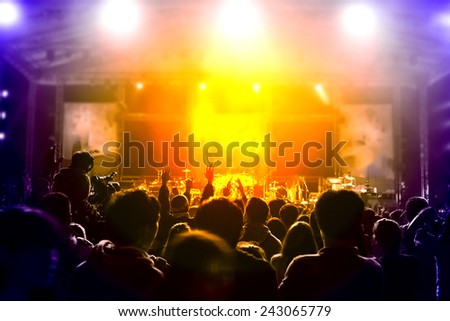 cheering fans put hands up during a live concert ,visible noise due high ISO, soft focus, slight motion blur
