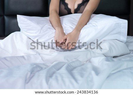 Woman use hand hugging pillow on the bed