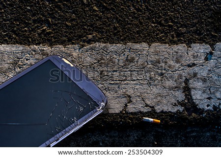 Broken glass of smartphone on road