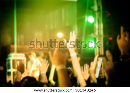 Out of focus crowd of Audience enjoying music in concert on stage