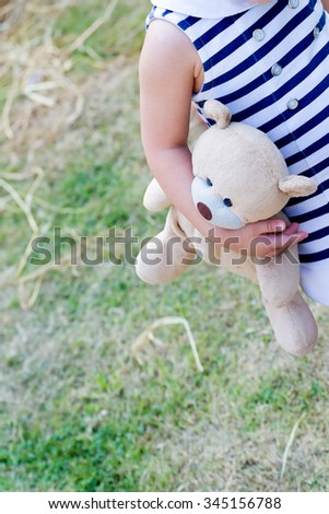 little girl holding her doll all time, parenting or love concept