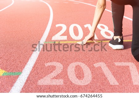 Athlete on Starting line waiting for the start in running track with text 2017 year, Start to new year