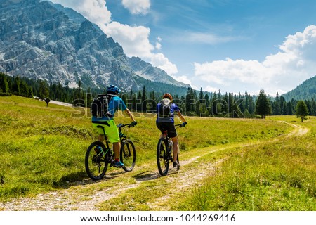 Mountain biking couple with bikes on track, Cortina d\'Ampezzo, Dolomites, Italy