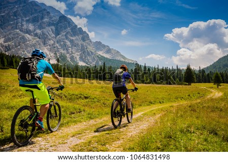 Mountain cycling couple with bikes on track, Cortina d\'Ampezzo, Dolomites, Italy