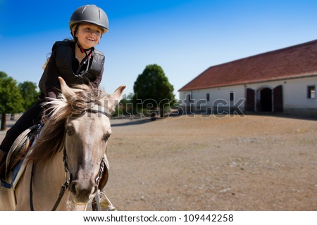 Horseback riding, lovely equestrian - little girl is riding a horse