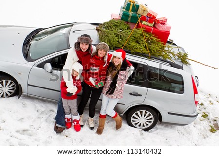 Waiting for Christmas  - the family is carrying  Christmas tree and gifts on the roof of the car