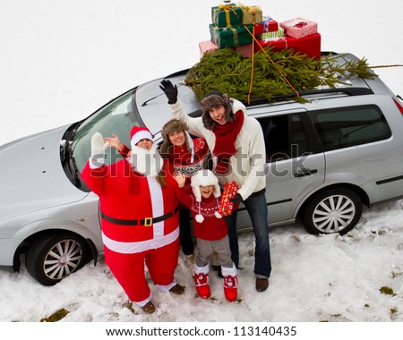Waiting for Christmas, Santa Claus - family is carrying  Christmas tree and gifts on the roof of the car
