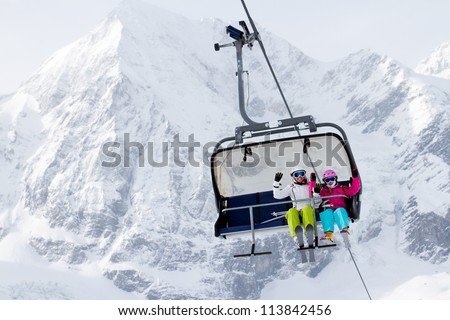 Skiing, winter - happy skiers on ski lift