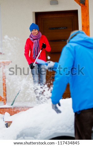 Winter, snow - the family is clearing of snow in front of the house and car