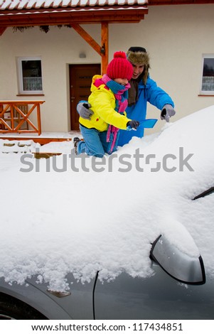 Winter, snow, car -  the family is having a good time clearing the car of snow