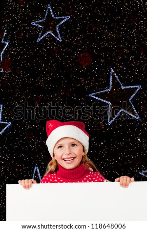 Christmas night, lovely girl in Santa hat and white board - space for text