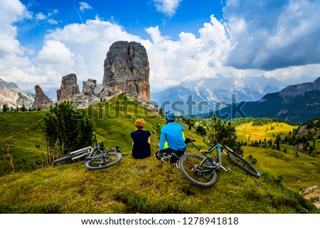 Mountain cycling couple with bikes on track, Cortina d\'Ampezzo, Dolomites, Italy