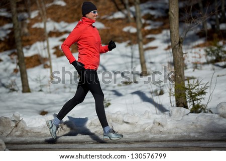 Runner, spring running, exercise woman. Jogging on early spring in mountains. Healthy lifestyle concept.