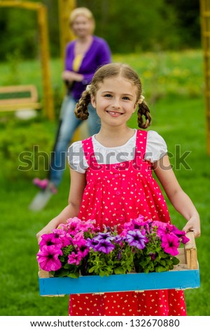Gardening, flower garden, planting concept - lovely gardener working with mother in the garden