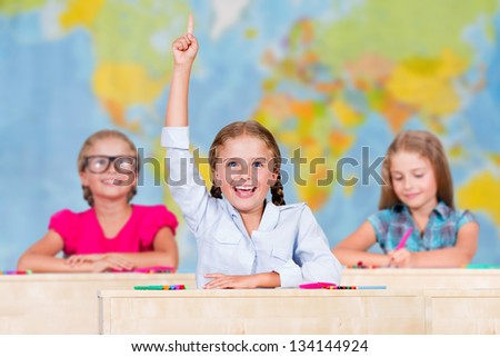 Back to school - elementary school pupil raising hand