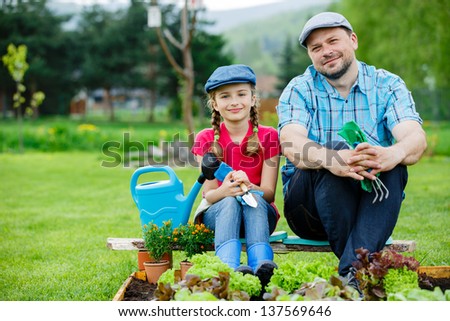 Gardening, planting, cultivation - young girl with father working in vegetable garden