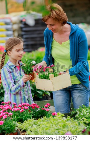 Mother with daughter shopping plants and flowers in garden center