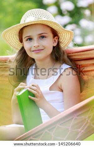 Summer joy, hammock - lovely girl with book in a hammock, rest in the garden concept