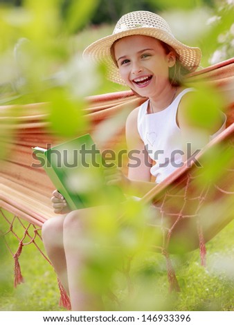 Summer joy, hammock - girl with book resting on a hammock in the garden