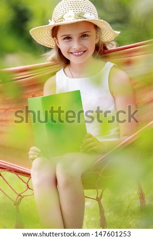 Summer joy, hammock - girl with a book resting on a hammock in the garden