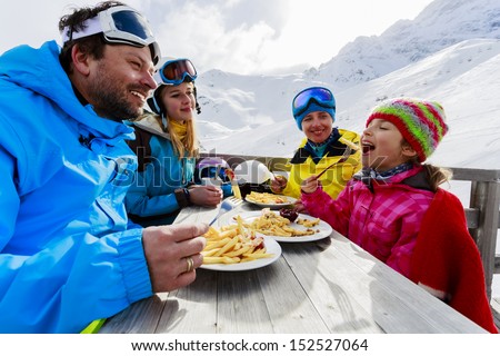 Winter ski skiers enjoying lunch in winter mountains Winter ski skiers enjoying lunch in winter mountains