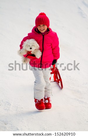 Winter play, snow, sledding - beautiful girl with dog has a fun on snow