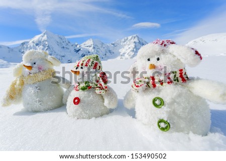 Winter, snow, sun and fun,  Christmas - happy snowman friends and snowy mountains in background