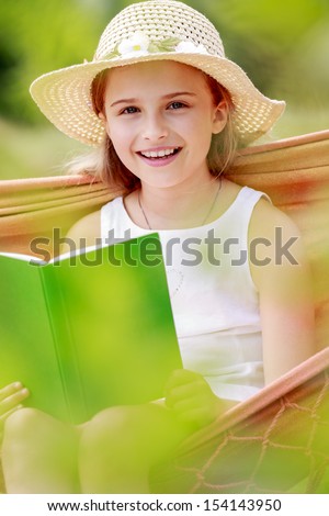 Summer joy, hammock - girl with a book resting on a hammock in the garden