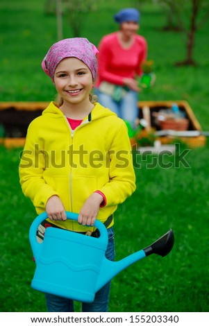 Gardening - girl helping mother in the garden