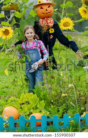Gardening, Scarecrow and happy girl  in the garden - Autumn harvests